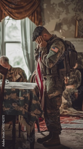 A soldier in military uniform, head bowed in a solemn moment with the American flag draped beside him.
