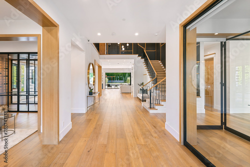 a house foyer features hardwood floors and modern staircases and wooden floors
