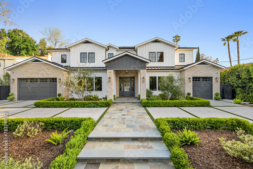 a house with driveway and stairs leading to the front door © Wirestock