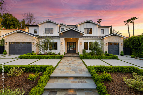 the house is surrounded by hedges and trees with palm trees around it