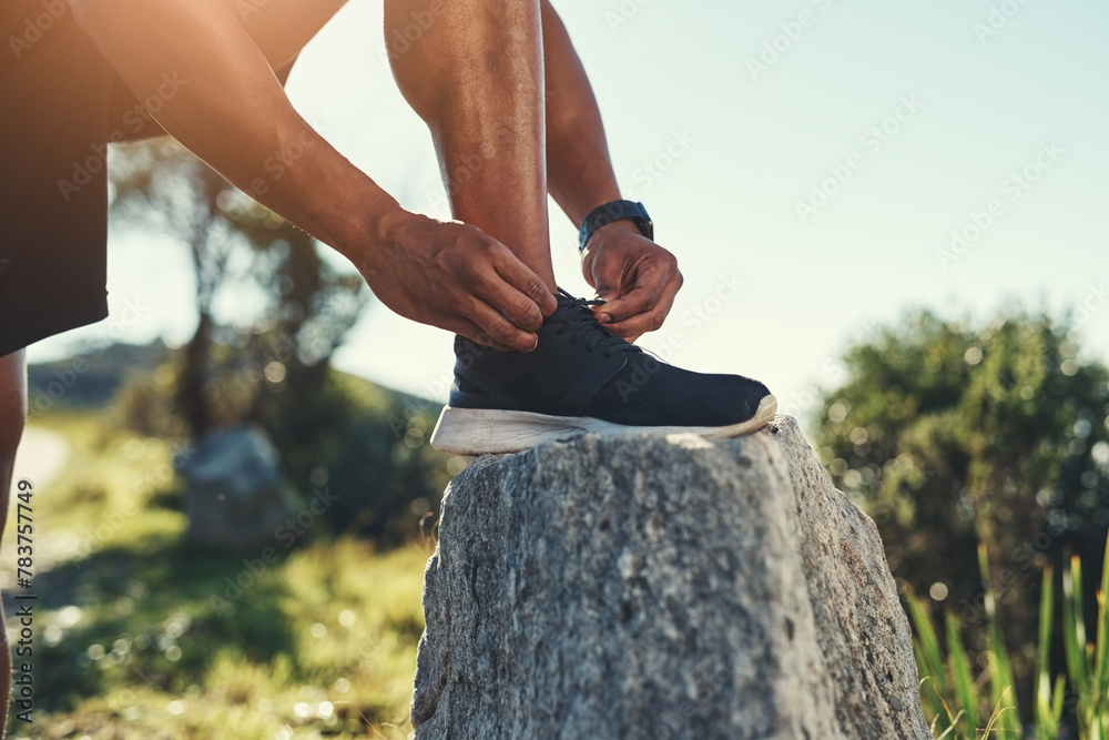 Obraz premium Runner, legs and tie shoelaces on rock, outdoors and prepare for cardio and marathon training. Man, stone and shoe for exercise or sports in nature, getting ready and foot for workout or athlete