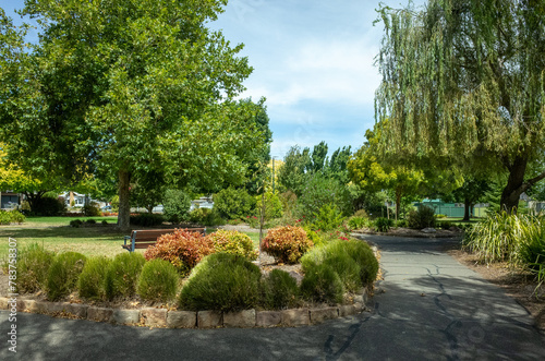 A landscaped urban garden featuring a variety of trees and plants, with pedestrian walkways inviting leisurely strolls. Cato Park. Stawell, VIC Australia