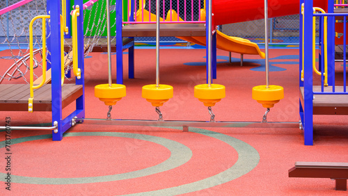 Group of colorful playground climbing equipment with balance bridge on rubber floor in outdoors playground area at kindergarten © Prapat