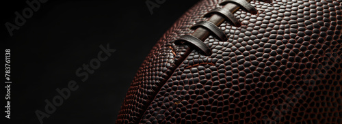 American football ball close-up texture on black background, copy space © Pixel Vest
