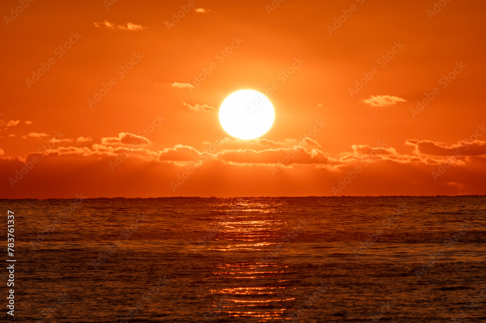 朝日に照らされてオレンジ色に染まる海