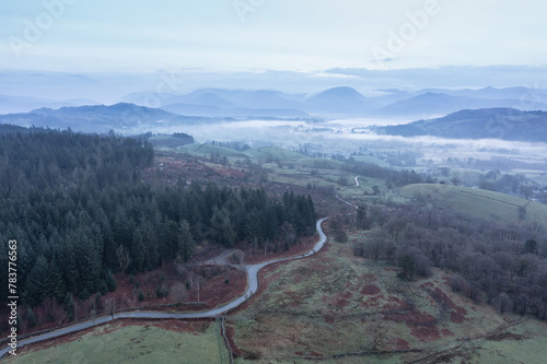 Stunning drone aerial landscape image of cloud inversion around Esthwaite Water in Lake District during Spring sunrise