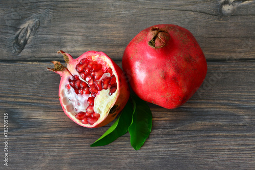 pomegranate and a half of pomegranate on a wooden table   