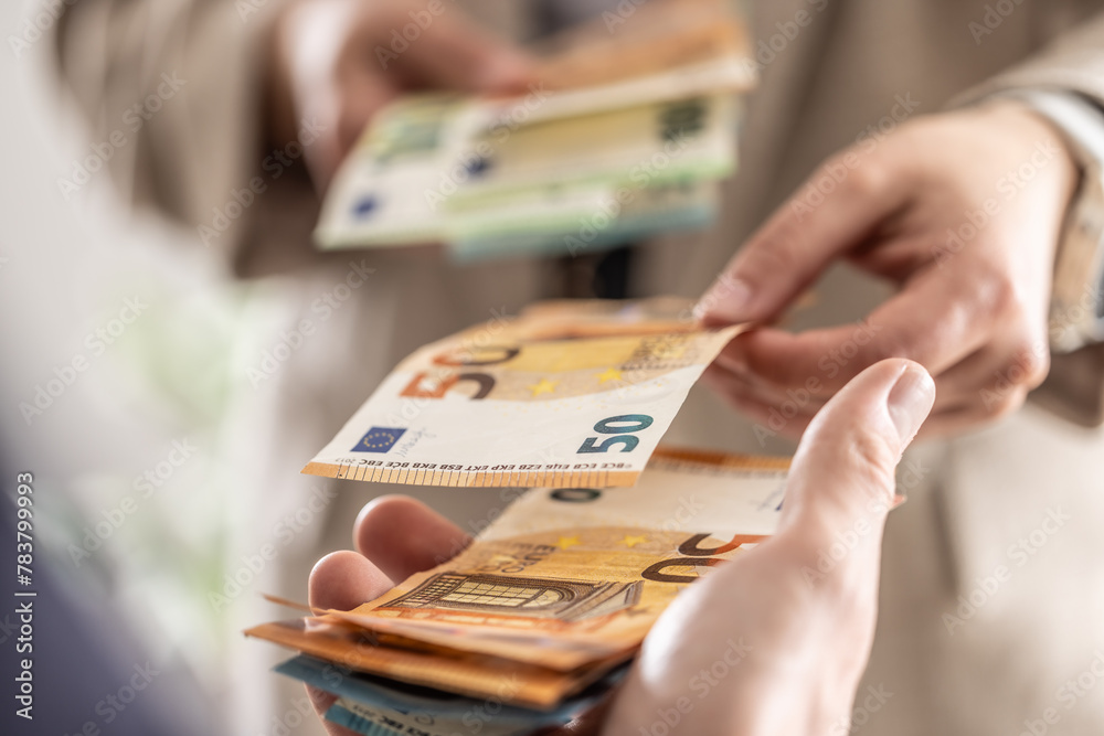 Businesswoman's hands exchanging euro banknotes, closeup shot