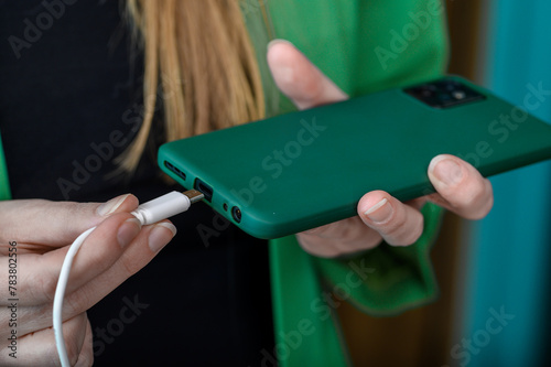 Dziewczyna podłącza telefon komórkowy do ładowarki 
