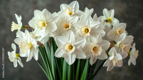  White daffodils in a green vase on a gray tablecloth against a black background