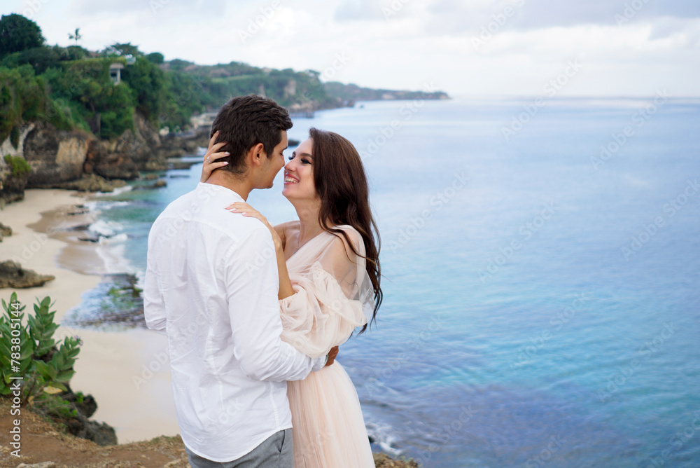 Wedding couple at breathtaking landscape with rock and ocean Wedding couple at breathtaking landscape with rock and ocean