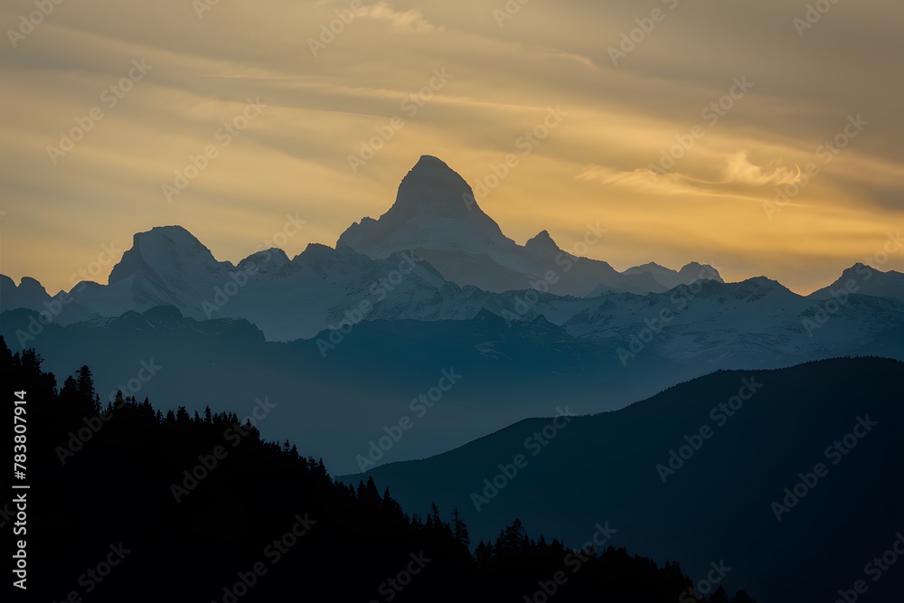 Majestic mountain peak silhouette backlit by yellow sunrise