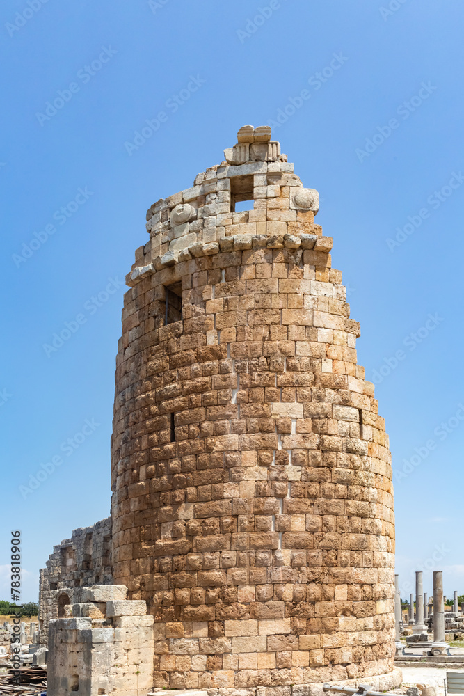Stone gate tower at Perge ancient city ruins under clear blue sky, a glimpse into Roman history. Antalya, Turkey (Turkiye)