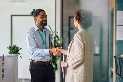 Happy black job candidate shaking hands with female CEO in office. photo
