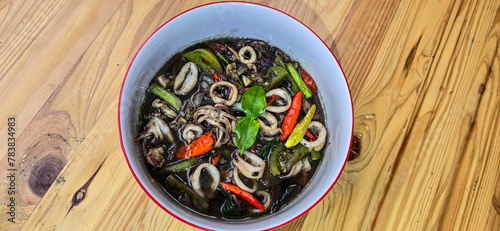 ndonesian home cooking menu, sauteed squid with black ink sauce with spicy seasoning called Tumis Cumi Hitam, including chili, ginger, and lime leaf photo