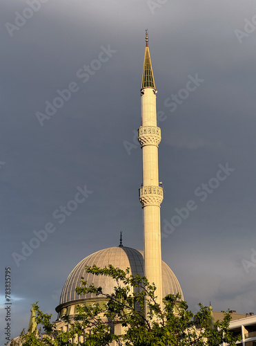 Late day sunlight shines on a beautiful minaret attached to a mosque in Izmir, Turkey; copy space