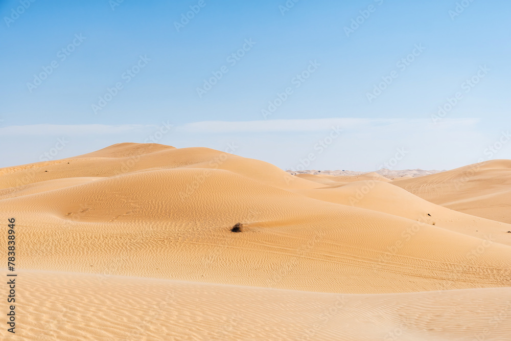 Wide desert sand dune with hills and blue sky. Wavy sand patterns. Abstract landscape backgrounds