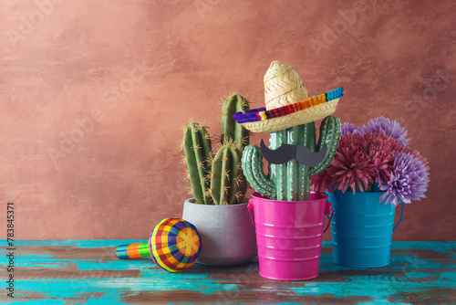 Mexican party concept with cactus and sombrero hat on wooden blue table over wall background. Cinco de Mayo holiday celebration