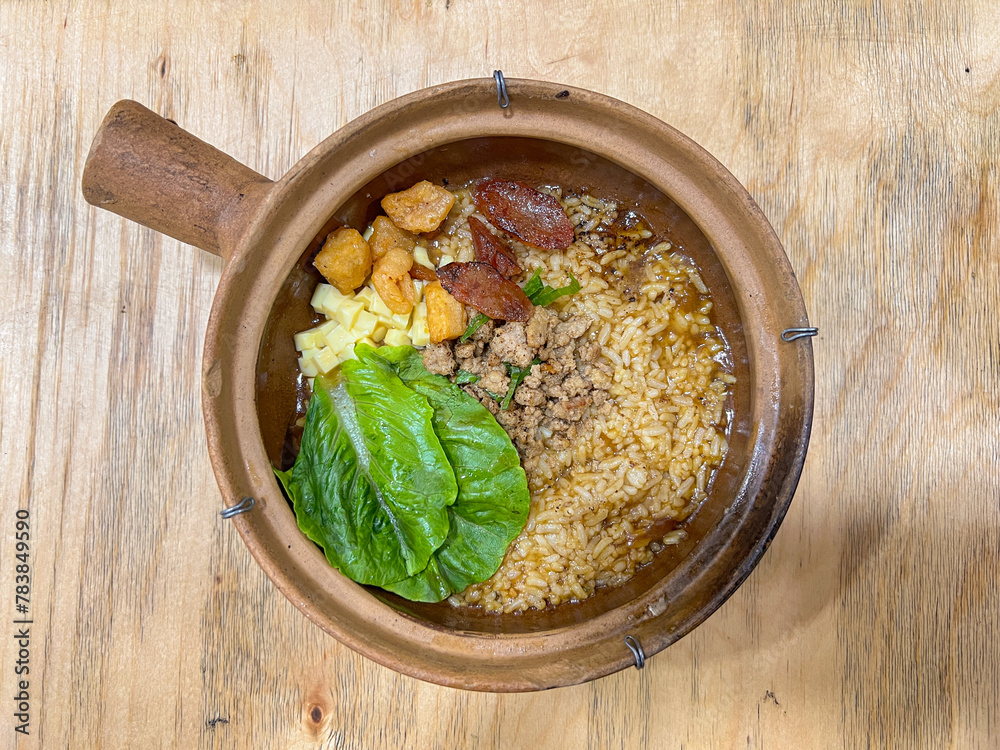 Claypot Rice, Rice cooked inside hot claypot served with crispy pork belly, pork sausages, minced meat, tofu and savory soup Claypot Rice, Rice cooked inside hot claypot served with crispy pork belly, pork sausages, minced meat, tofu and savory soup