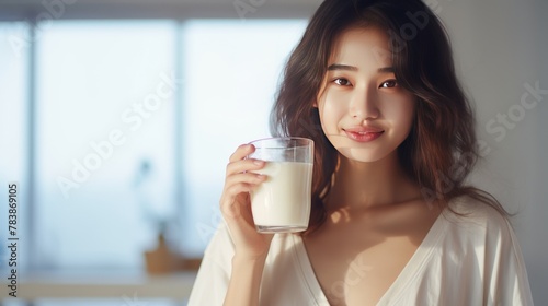 Young Asian woman holding a glass of milk 
