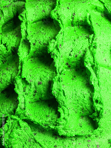 Frozen Cannabis flavour gelato - full frame detail of sorbet. Close up of a green surface texture of Ice cream filled with pieces of mixed fruits.