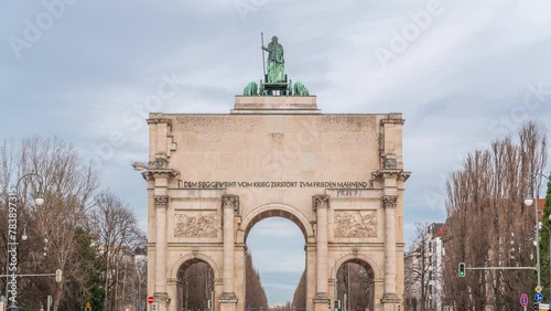 The Siegestor or Victory Gate in Munich is a memorial arch, crowned with a statue of Bavaria with a lion quadriga timelapse. Traffic on the street around the monument. Back view. Germany photo