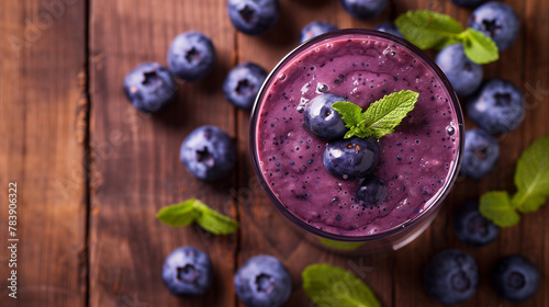 A glass with blueberry smoothie on a wooden table
