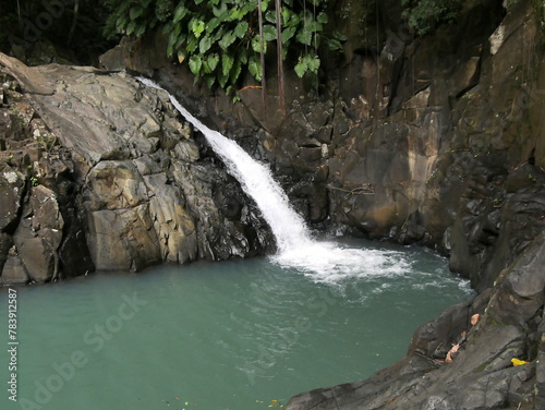 Saut d'acomat, tropical waterfall in basse terre, guadeloupe. Caribbean fall in the jungle and pond surrounded by rock photo