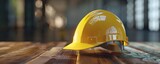 Yellow construction safety helmet on a wooden background. Industrial safety and labor protection concept for design and print