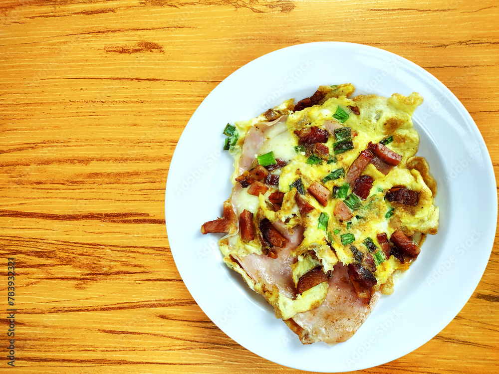 Top view of complete Omelette with bacon, ham, chesse on the wooden background
Top view of complete Omelette with bacon, ham, chesse on the wooden background