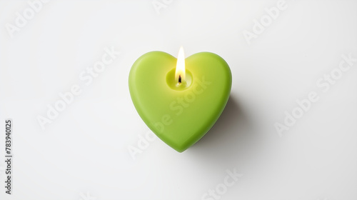 one green color candle in the shape of heart on white background top view