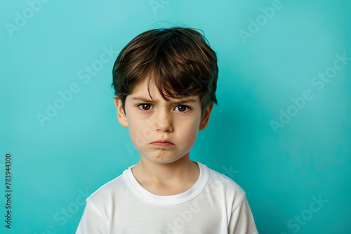 Young Boy with Serious Expression on Teal Background 