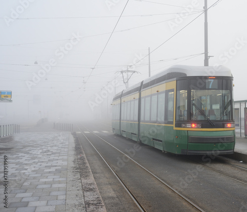 city tram number 7 at a stop early in the morning in the fog i