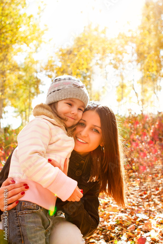 Happy mother and daughter in autumn park