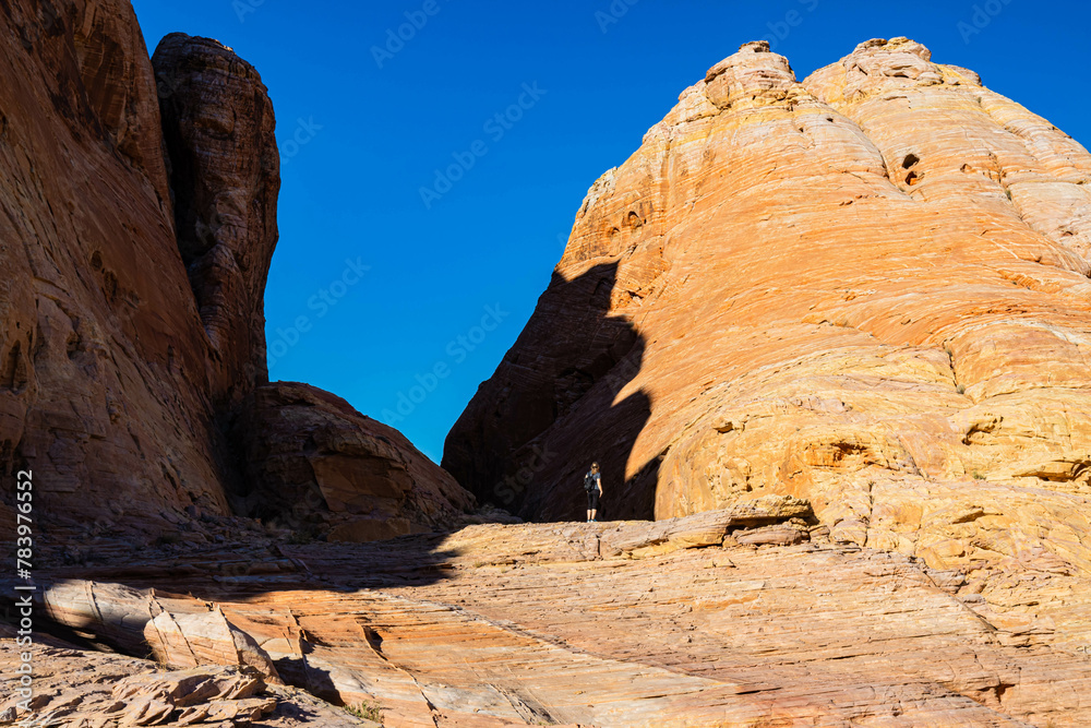Female Hiker on Aztec Sandstone Formations Near The Upper Fire Canyon Wash, Valley of Fire State Park, Nevada, USA