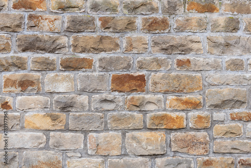 old stone wall background in different natural colored stone bricks