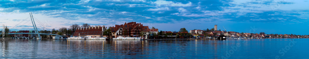  2023-04-28; panorama Mikolajskie Lake of town, marina for yachts and boats at the waterfront. Mikolajki, Poland.