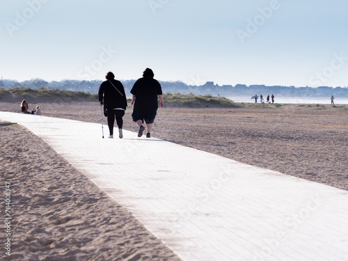 obesity, a problem of people in the 20th century, a walk, a way to lose weight, fresh air, a walking path, sea sand, beach photo