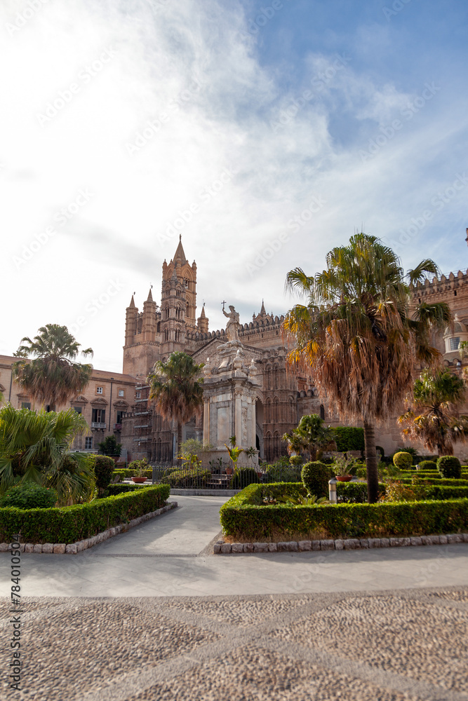 Palermo Cathedral stands regal under the sky, flanked by the verdant gardens and the revered statue of Santa Rosalia, Sicily, Italy