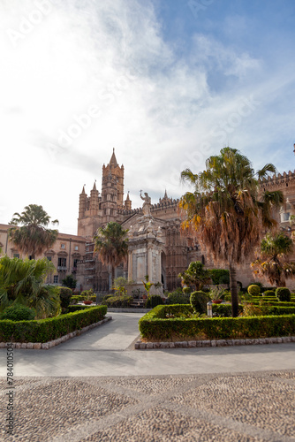 Palermo Cathedral stands regal under the sky, flanked by the verdant gardens and the revered statue of Santa Rosalia, Sicily, Italy