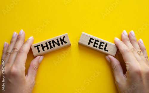 Think or Feel symbol. Concept word Think or Feel on wooden blocks. Businessman hand. Beautiful yellow background. Business and Think or Feel concept. Copy space