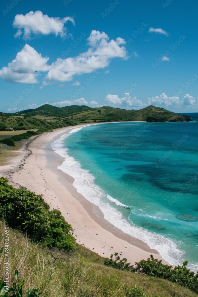 A panoramic view of a long, pristine beach stretching towards the horizon, flanked by lush green hills and crystal-clear turquoise water