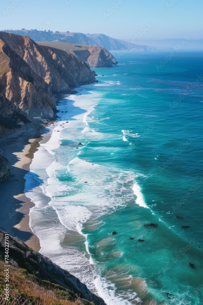 A panoramic view of a long stretch of pristine coastline, with turquoise waves crashing against the shore and dramatic cliffs