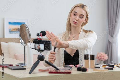 Young woman making beauty and cosmetic tutorial video content for social media. Beauty blogger smiles to camera while showing how to beauty care to audience or followers. Panorama Blithe