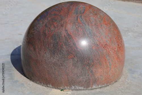 Granite brown ball on gray concrete © andsy