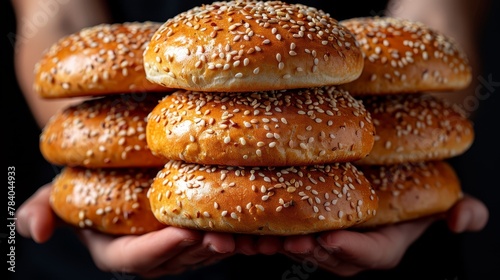   A palms-full of stacked sesame seed bagels photo