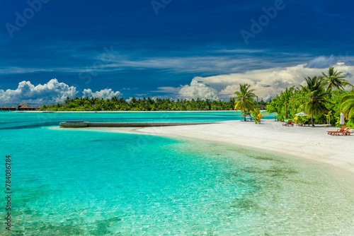 Palm trees and beach umbrelllas over lagoon and sandy beach, Maldives island © FaiV007