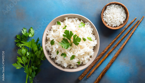 White rice bowl garnished with fresh parsley on a blue background. photo