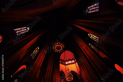 Teto de catedral com lustre, vitrais e sombras. photo