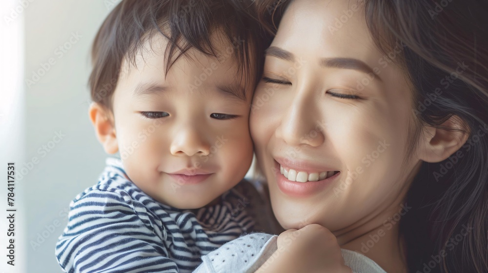 Asian mother hugging her child on background Asian mother hugging her child on background